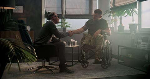 Senior psychologist supports Black male military veteran in wheelchair after therapy session — psychological help and rehabilitation