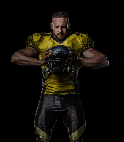 Black male athlete in American football gear — representing the concussion conversation in sports